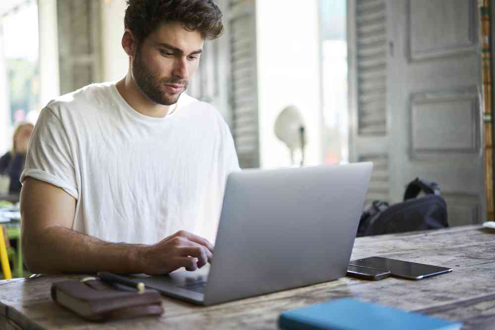 Concentrated,Good,Looking,Freelancer,Dressed,In,White,T-shirt,Working,Distantly