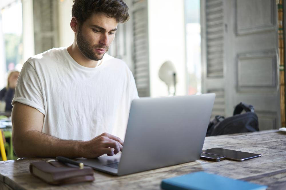Concentrated,Good,Looking,Freelancer,Dressed,In,White,T-shirt,Working,Distantly